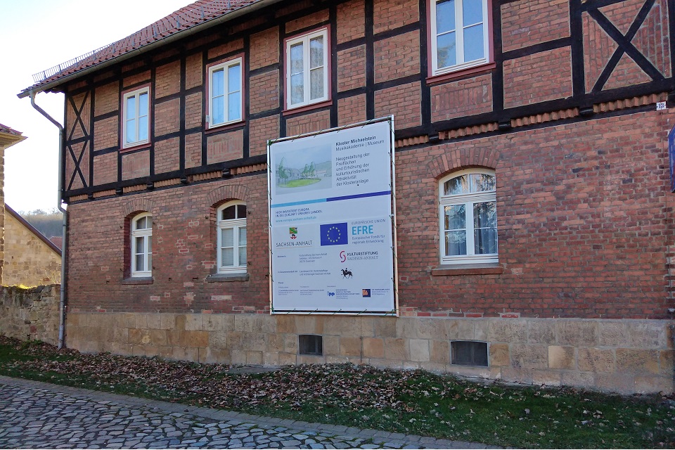 Zu jeder Baustelle gehört auch ein Baustellenschild mit Nennung der Fördermittelgeber und Projektpartnern. Das Baustellenschild hängt vor dem Torhaus am Inspektorenhaus.