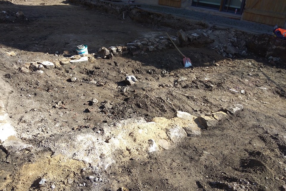 Als die ersten Erdschichten abgetragen waren, kamen im Untergrund Fundamentreste zu Tage. Das Baugeschehen musste an dieser Stelle gestoppt werden und die Archäologen kamen.