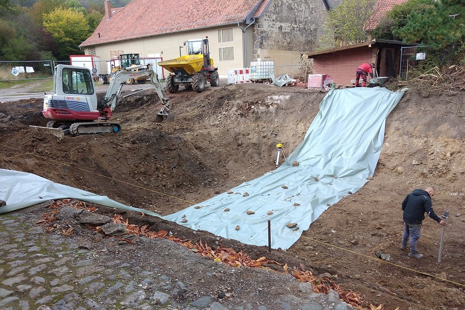 Die Baugrube wird nach ihrer Herstellung mit Folien überdeckt, um Abrutschen des Erdbodens durch Nässe zu verhindern.